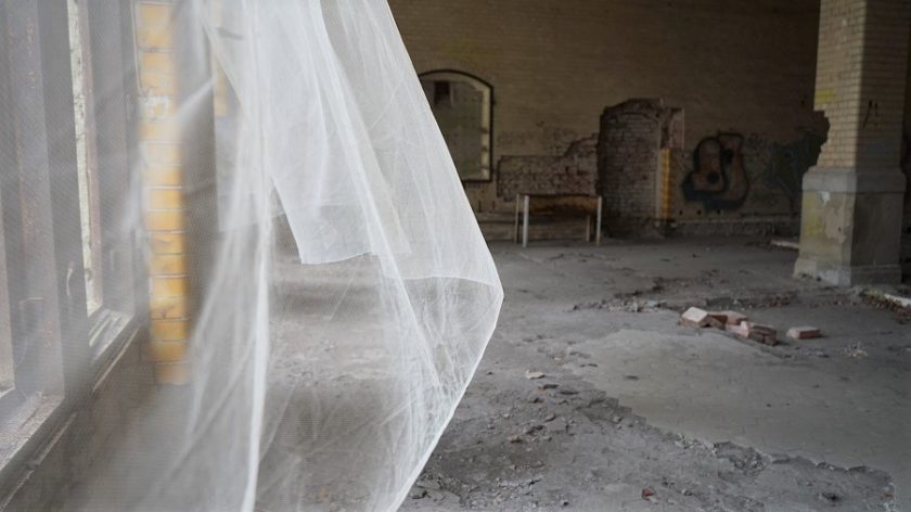 Alte Gardine weht im verlassenenBadesaal der Beelitzer Heilstätten.