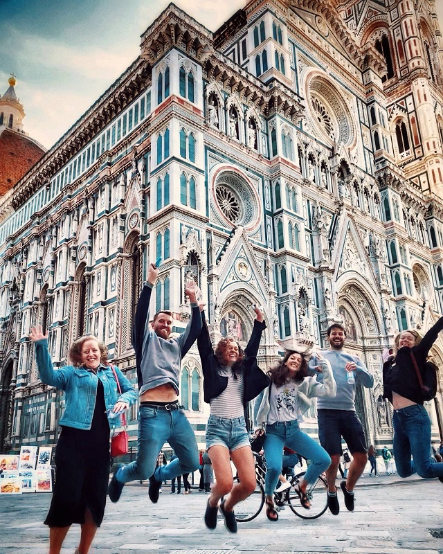Toskana Roadtrip Jugendliche springen vor dem Dom von Florenz in die Luft